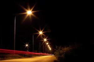 encienda la lámpara con los faros en la carretera en la oscuridad. foto