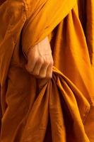 Close-up of monk hands holding his robes. photo