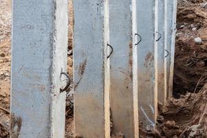 Close-concrete pillars installed in a trench dug soil. photo