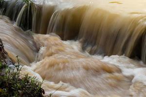 The turbid water flows like a waterfall. photo