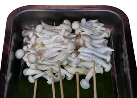 Small mushroom skewers put in a tray. photo