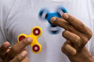 Blue and yellow spinners both in hands. photo