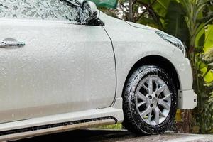 Lavado de coches en spray de espuma blanca.