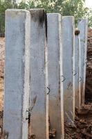 Many concrete poles in the excavated soil for construction.