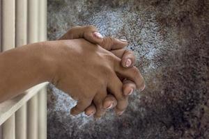 Hand clasped in the prison with abstract walls. photo