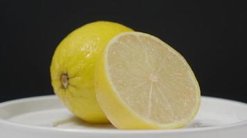délicieux citron se déplaçant sur le plateau tournant isoler sur le fond noir. video