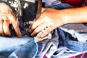 reparar jeans con una vieja máquina de coser. foto