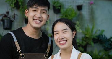 Feche o rosto do proprietário de jardineiro casal asiático feliz sorrindo e olhando para a câmera no jardim. vegetação em casa, venda on-line e conceito de hobby.