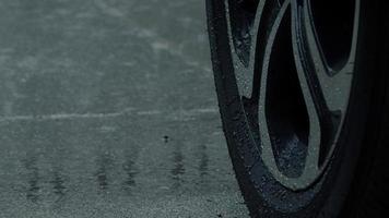 salpicos de chuva e pneu de carro na água da chuva. estacionamento na chuva. video