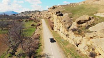 Uplistsikhe, Georgia - 26th March, 2021. Aerial tracking tilt down view lexus car driving to sightseeing destination