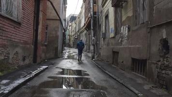 Male person walks alone street with face mask being thoughtful. Conceptual lifestyle pandemic video