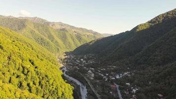 Aerial view of Pasanauri town houses in georgian countryside with flowing Aragvi river. KAzbegi national park video