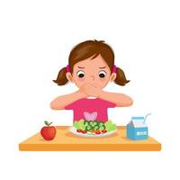 linda niña quisquillosa infeliz cubriendo su boca negándose a comer verduras vector