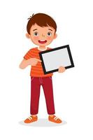 niño feliz sosteniendo una tableta digital con el dedo apuntando a una pantalla vacía o copiando espacio para textos, mensajes y contenido publicitario. concepto de niños y dispositivos electrónicos para niños vector