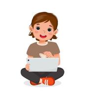Cute little girl sitting on floor using digital tablet touching screen browsing internet, doing homework, and playing games. Kids and electronic gadget devices concept for children vector