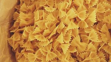 Close up view raw farfalle type pasta in bag on display on market