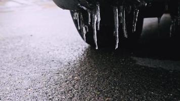 Low angle view of small melting icicles on cars bumper. Springtime and road conditions concept video