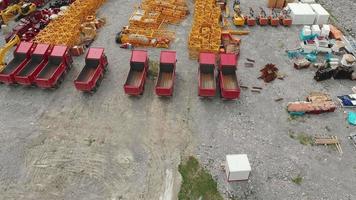 Aerial fly over empty trucks and tractors parked on ravel road in a field not used video