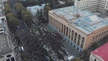 1º de novembro de 2020. tbilisi.georgia.ascending vista aérea frontal até multidões de pessoas reunidas protestando em frente ao prédio do parlamento.post protestos eleitorais do parlamento no cáucaso. video