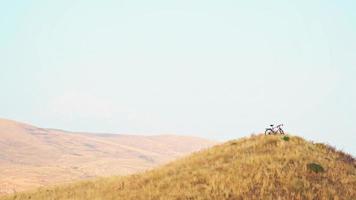 vélo rouge sur le sommet de la colline sans cycliste et montagnes pittoresques à l'extérieur de l'arrière-plan sauvage