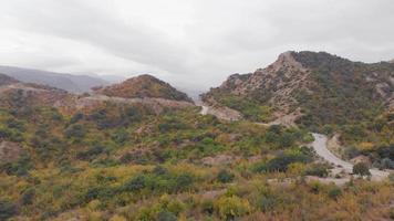 vista aérea de um carro subindo a colina em localização de montanha tranquila cênica no conceito de fundo de aventura viagem viagem caucasus.road. video
