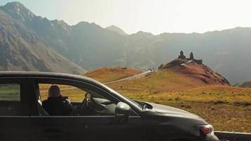 Seitenansicht einer Frau im Auto mit Telefon, die berühmte Touristenattraktion in der Ferne fotografiert video