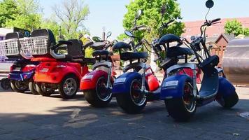 palanga, lituania, 2021 - muchos coloridos scooters eléctricos de neumáticos gordos estacionados para alquilar en el famoso balneario público de lituania. video