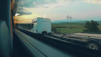 Blick durch das Busfenster auf die Naturlandschaft bei Sonnenuntergang in Bewegung. Sightseeing-Tour und Reisen. urlaub im ländlichen kaukasus. video