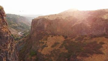 Birds eye view scenic Garni gorge cliffs landscape with balloons in background at sunrise in Armenia video