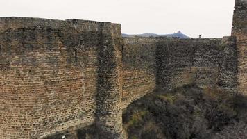 Pan aérea vista marco histórico fortaleza antiga muralha em mtskheta. video