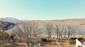 Descending cinematic view Lisi lake with people by the lake in spring. Big city Tbilisi get away nature concept video