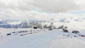 Pistas de esqui de vista aérea cinematográfica em câmera lenta na estância de esqui de gudauri com fundo de montanhas do cáucaso.