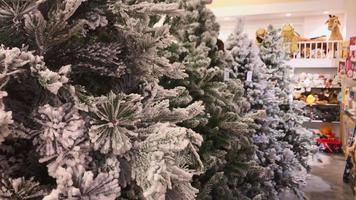 tbilissi, géorgie, 2021 - arbres de noël en plastique blanc exposés dans un magasin avec fond de décorations de noël video