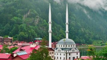 Beautiful white mosque exterior architecture at Uzungol lake coast in the morning with misty green mountains nature video