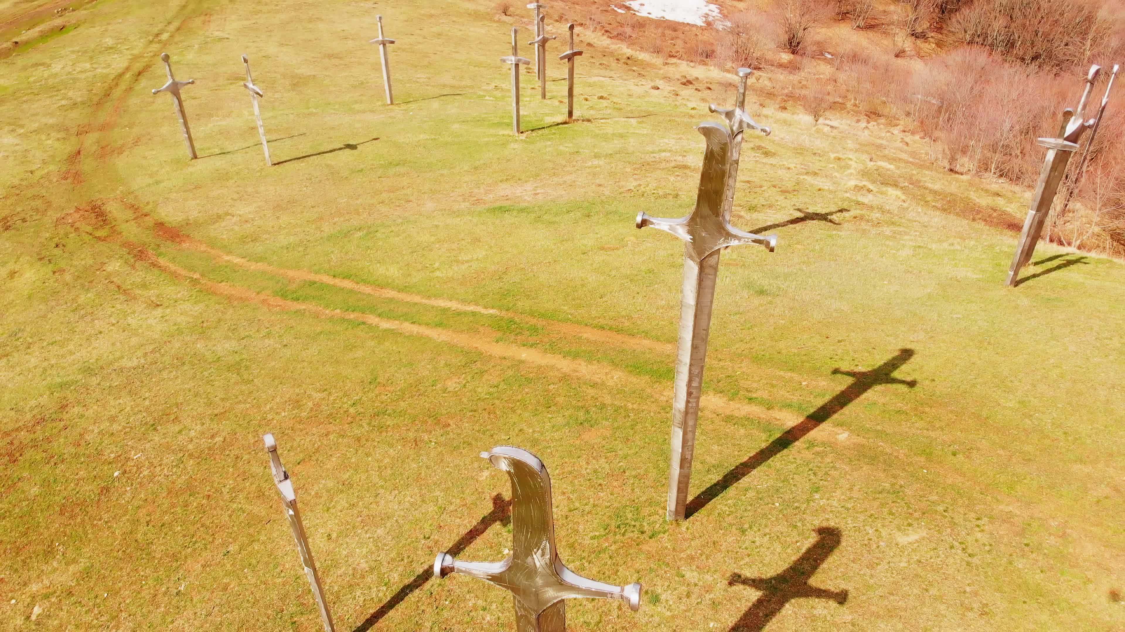 Aerial rising view symbolic steel sword statues in ground in Didgori