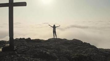 inspirierende luftaufnahme um siegreiche junge attraktive frau mit ausgebreiteten händen über den wolken. Tagträumendes Konzept video