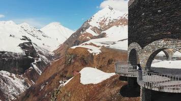 Young woman standing alone in scenic viewpoint and being thoughtful alone while travel with mountains background in spring. video