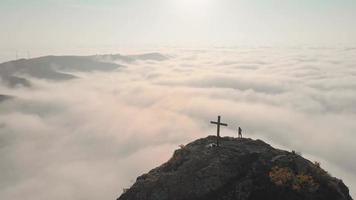 Beautiful panoramic view of female person silhouette standing above clouds on viewpoint of beautiful panorama
