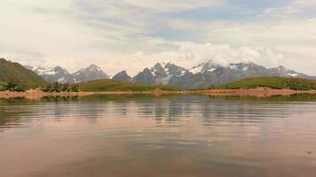 amplia escena tranquila de ondas de agua del lago con picos de montaña sobre el fondo del horizonte