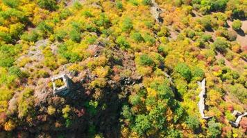 Aerial circle around Georgian Rkoni fortress ruins surrounded by autumn color trees video