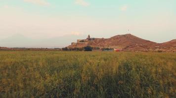 luchtfoto snelle beweging zoom in weergave historisch monument in armenië - khor virap klooster met ararat bergtop achtergrond bij zonsopgang video