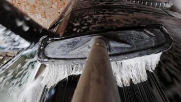 Makroansicht seifige Bürste, die schwarzes Auto wäscht video
