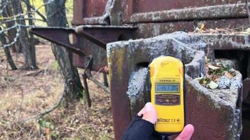 Chernobyl, Ukraine, 2019 - Close up of male hand holding Geiger counter by the metal surface of old soviet metal construction. video