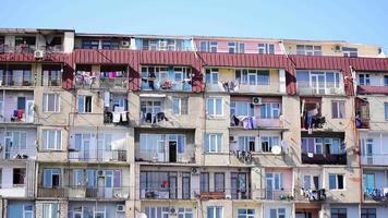 Old Soviet building view with balconies and clothes drying out in balconies in sunny day. Lifestyle traditions caucasus.Georgia Republic video
