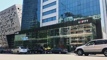 Tbilisi, Georgia, 2020 - Street view with cars passing and Liberty bank exterior building architecture. Economy and finances caucasus concept video