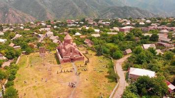 Aerial panning view tourists by Odzun church landmark with village houses panorama . Famous Armenian basilica constructed V - VII century in Lori province video