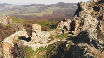 jonge vrouwelijke wandelaar buitenshuis verkent de historische ruïnes van het kojori-fort in georgië. reisbestemming Kaukasus. video