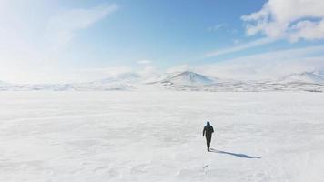 Back view male person films drone himself isolated in nature with winter background video