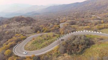 vista aérea de la carretera en las montañas del cáucaso con furgonetas y automóviles que pasan con un pintoresco paisaje otoñal de fondo.turismo y viajes georgia