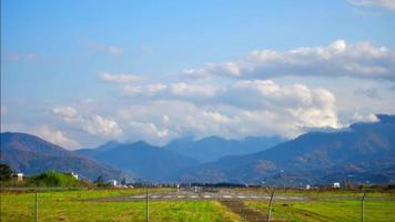 statische ansicht batumi flughafen landebahn mit verkehrsflugzeug abflugzeitraffer und kaukasus berge hintergrund video
